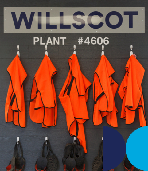 A wall of orange PPE for WillScot plant workers.
